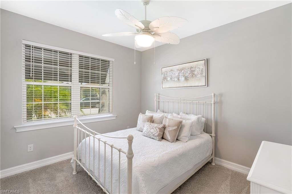Carpeted bedroom featuring a ceiling fan and baseboards