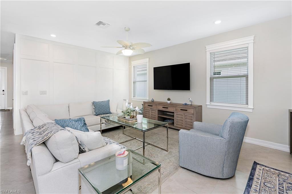 Living room with a ceiling fan, recessed lighting, and light tile patterned flooring