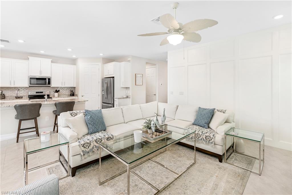 Living area with recessed lighting, a decorative wall, and ceiling fan