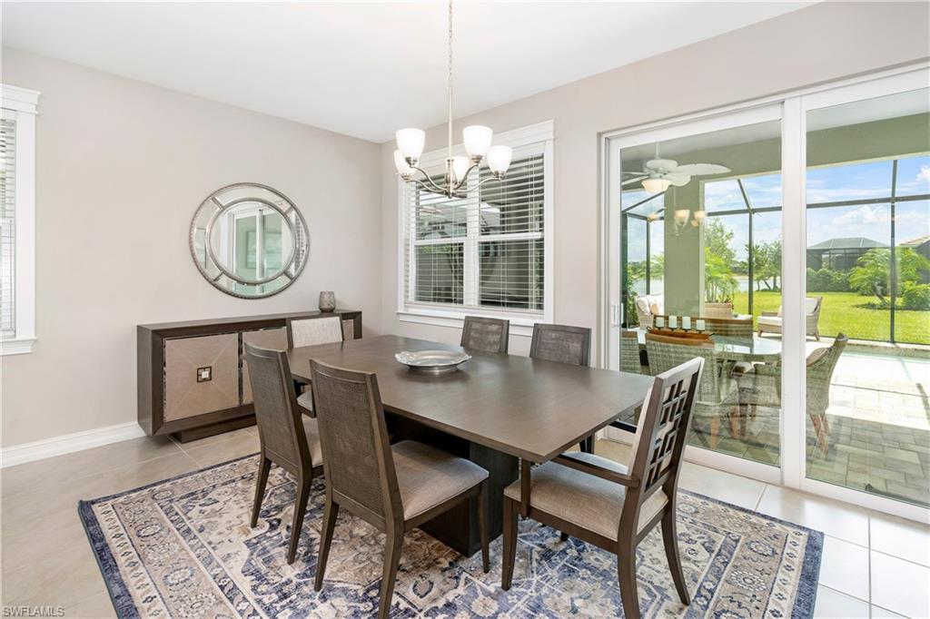 Dining room with healthy amount of natural light, light tile patterned floors, and a chandelier