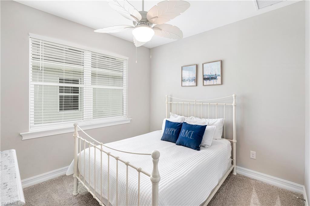 Carpeted bedroom featuring a ceiling fan and baseboards