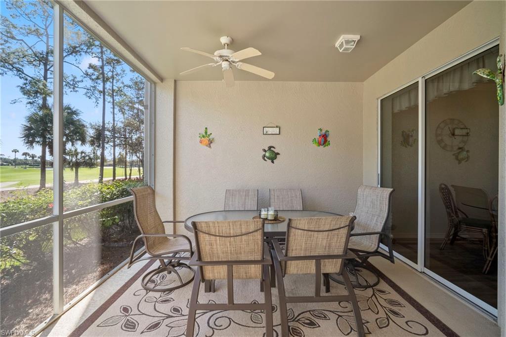 Sunroom with ceiling fan, outdoor dining space, and view of golf course