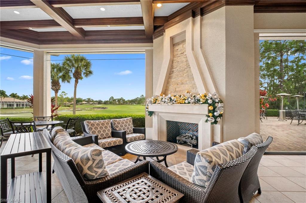 View of patio with view of golf course, an outdoor living space with a fireplace, and outdoor dining area