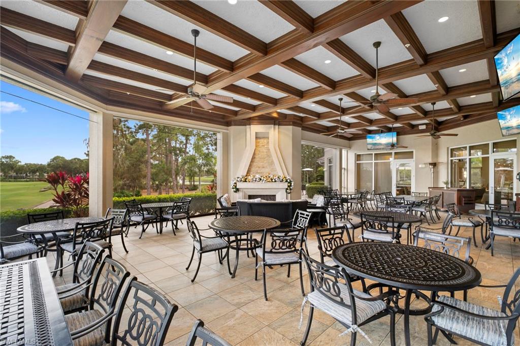 View of patio featuring a large fireplace, outdoor dining area, and ceiling fan