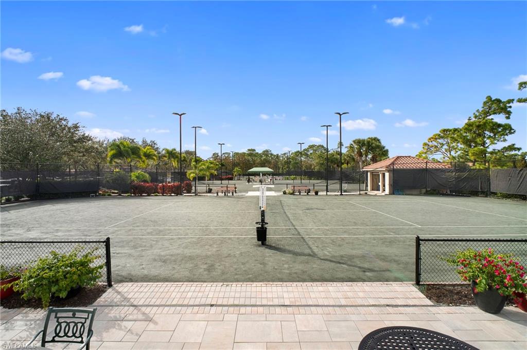 View of tennis court featuring community basketball court and a patio