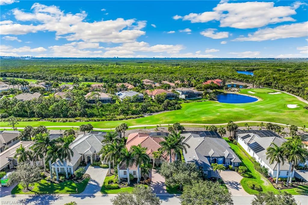 Aerial perspective of suburban area featuring a local golf course and a large body of water