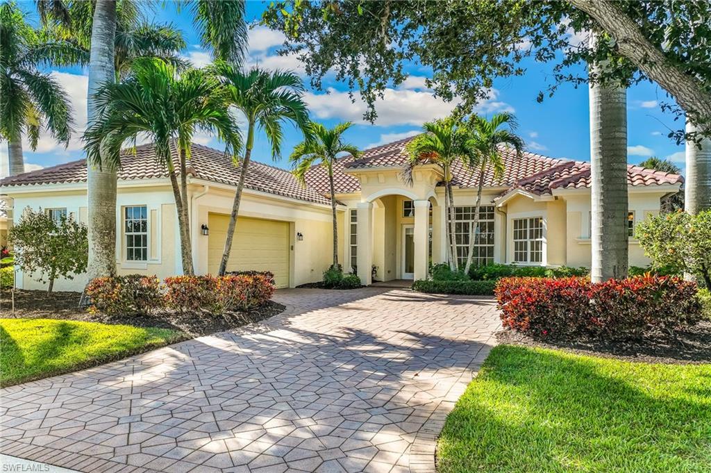 Mediterranean / spanish home featuring stucco siding, decorative driveway, an attached garage, and a front lawn