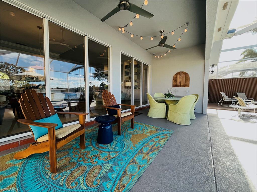 Covered Lanai w/Adirondack chairs and outdoor dining, string lights, and fans