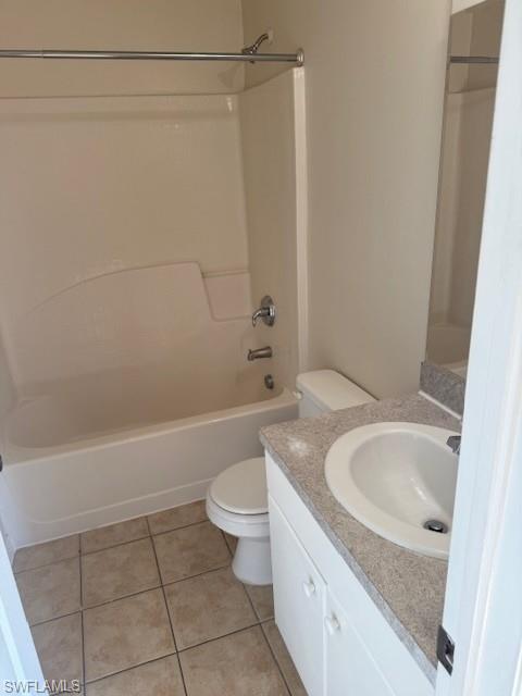 Full bath with vanity, light tile patterned floors, and bathing tub / shower combination