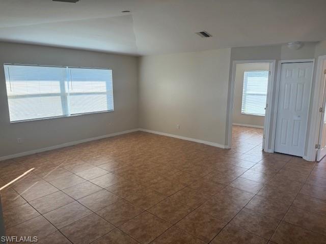 Tiled empty room with healthy amount of natural light