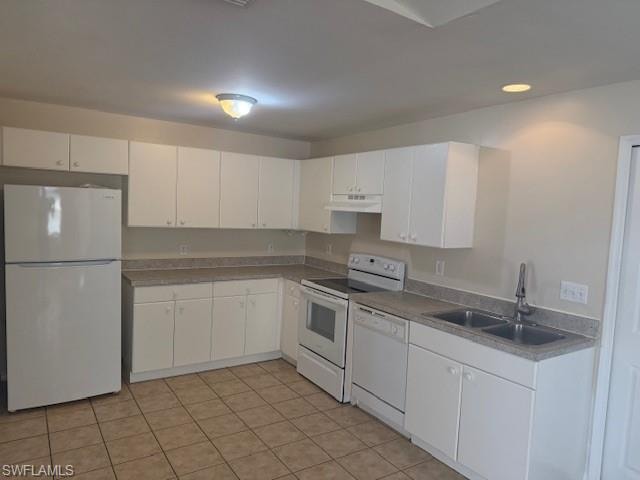 Kitchen featuring white appliances, white cabinets, under cabinet range hood, recessed lighting, and light tile patterned flooring