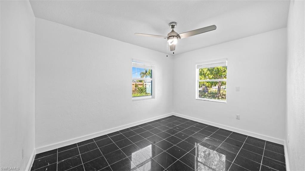 Spare room featuring baseboards and ceiling fan