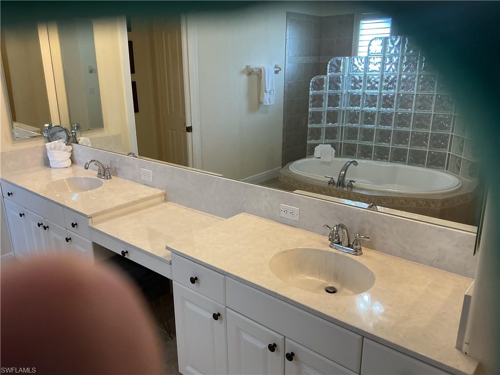Bathroom featuring double vanity, a bath, and walk in shower