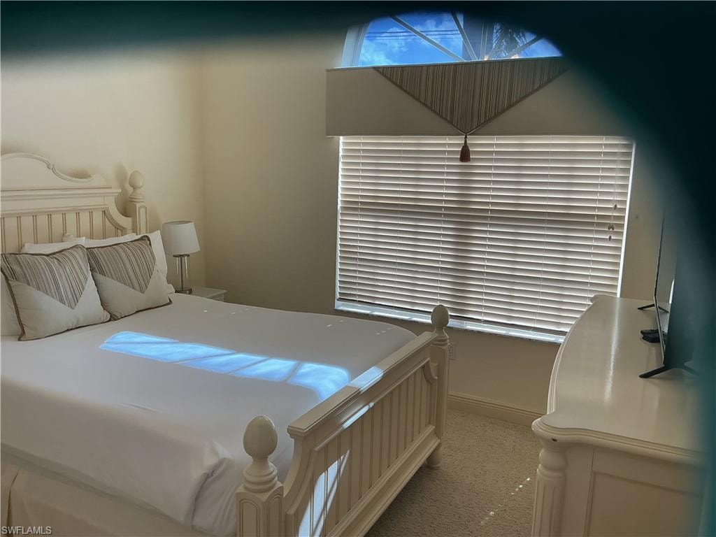 Bedroom featuring light colored carpet and baseboards
