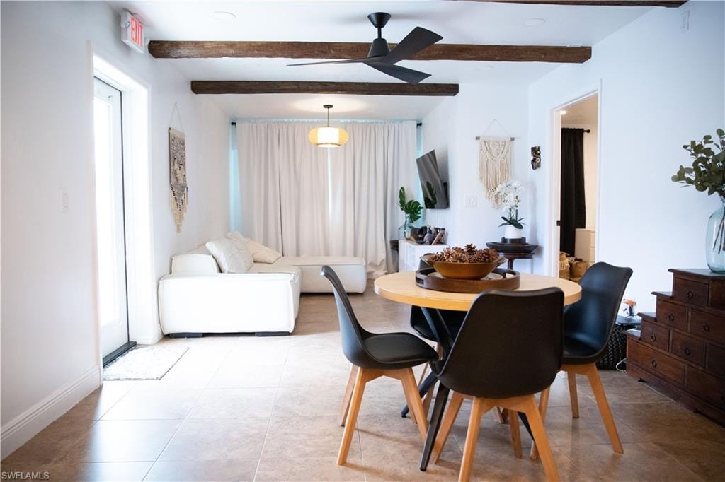 Tiled dining room with beamed ceiling and a ceiling fan