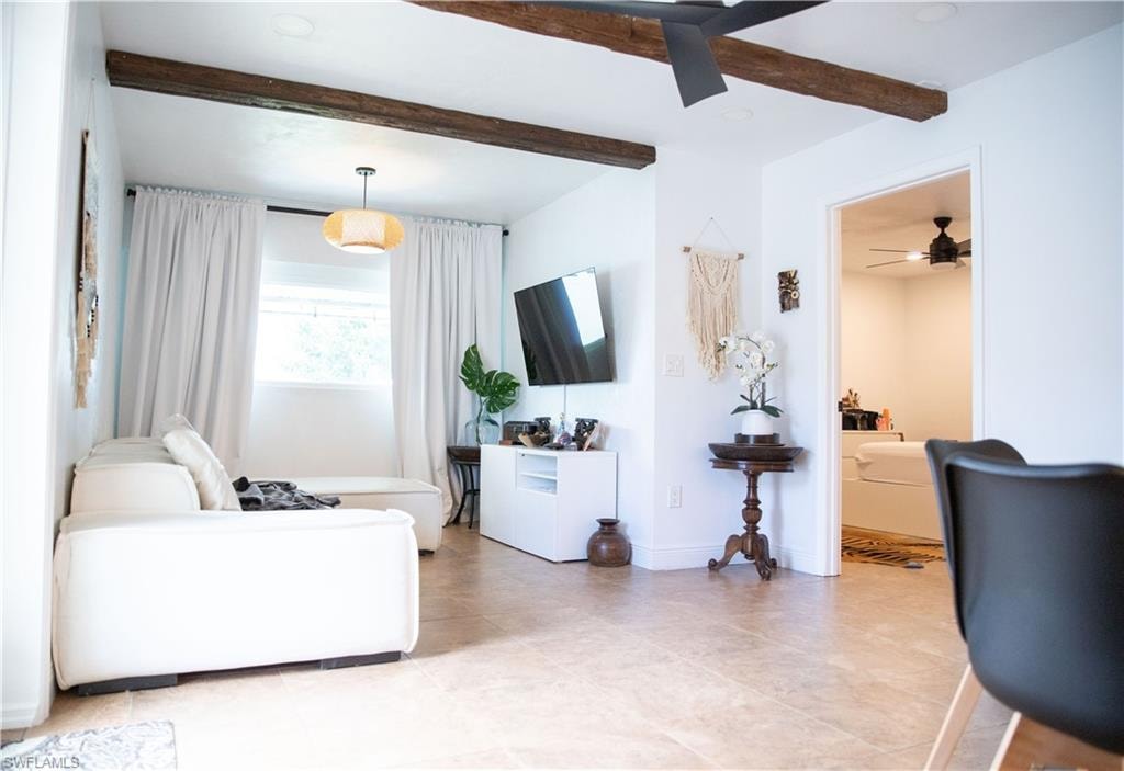 Living area featuring beam ceiling and a ceiling fan