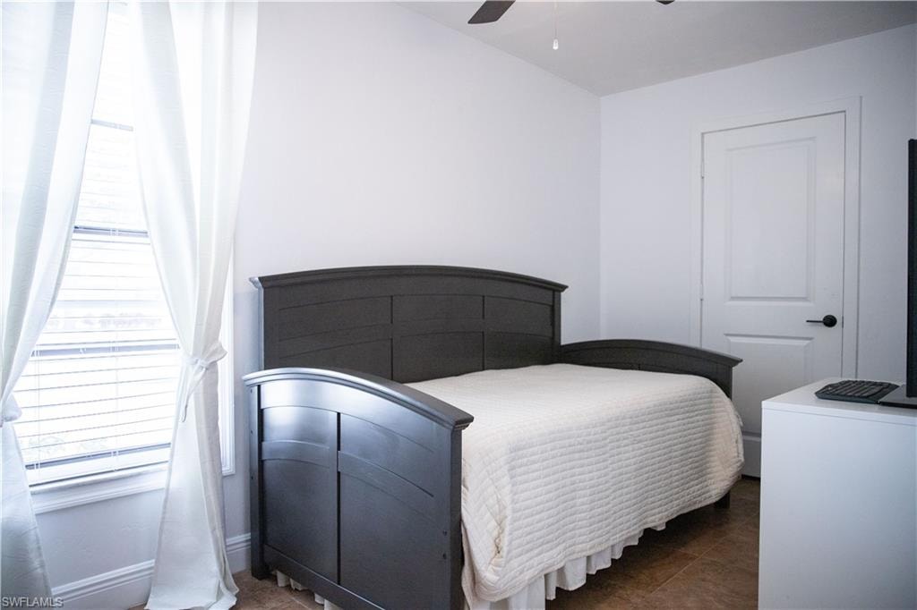 Bedroom featuring a ceiling fan and dark tile patterned floors