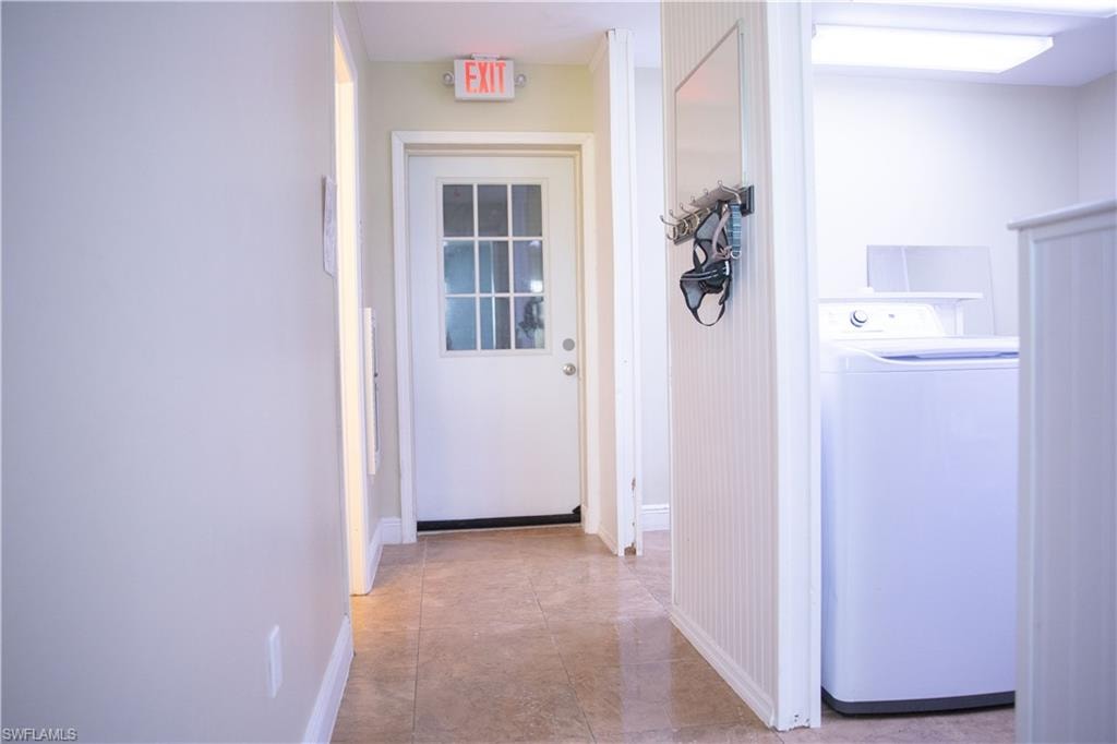 Hall with washer / clothes dryer and baseboards