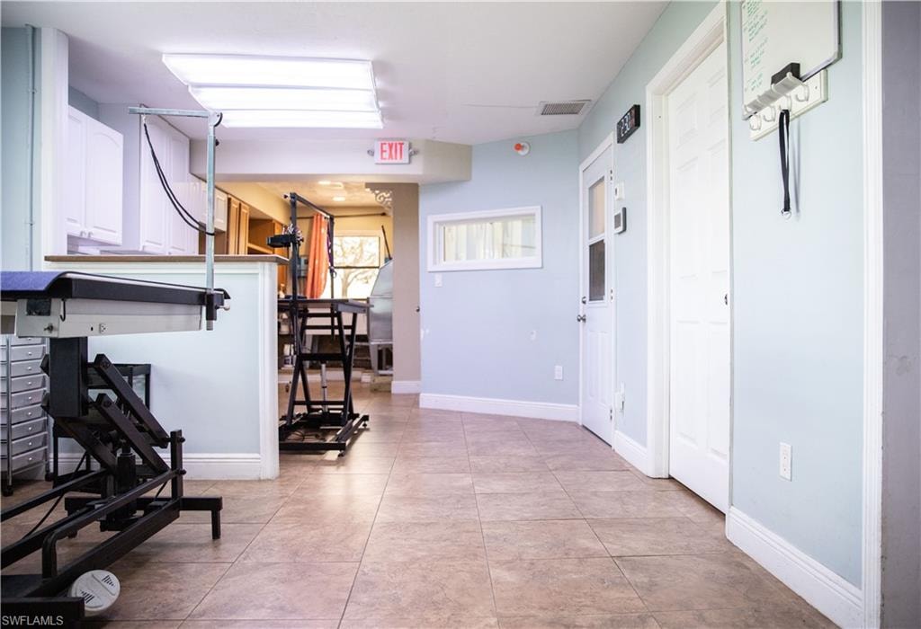 Hall with baseboards and light tile patterned floors