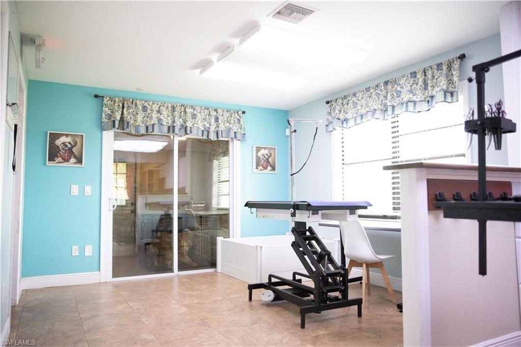 Workout room with baseboards and tile patterned floors