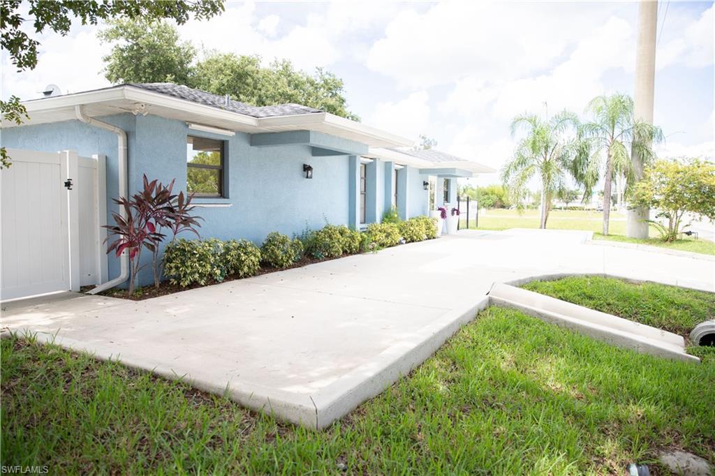 View of side of property featuring stucco siding and a gate