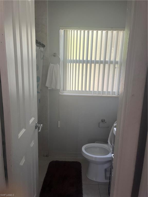Full bath with light tile patterned flooring and a shower with curtain