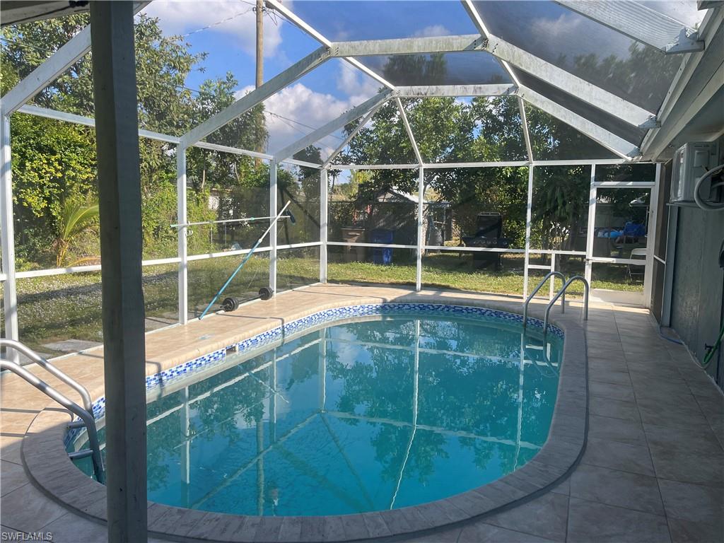 Swimming pool featuring a sunroom, a lanai, and a patio area