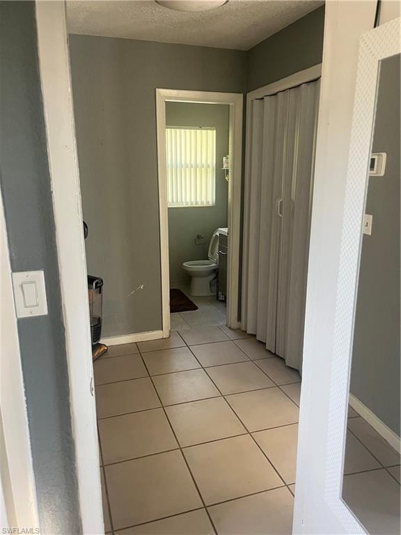 Bathroom with light tile patterned floors and a textured ceiling