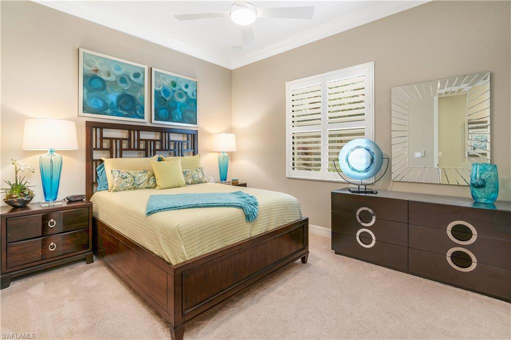 Bedroom with ornamental molding, a ceiling fan, and carpet flooring