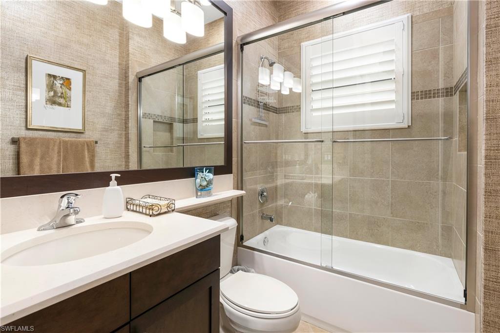 Full bath featuring vanity and bath / shower combo with glass door
