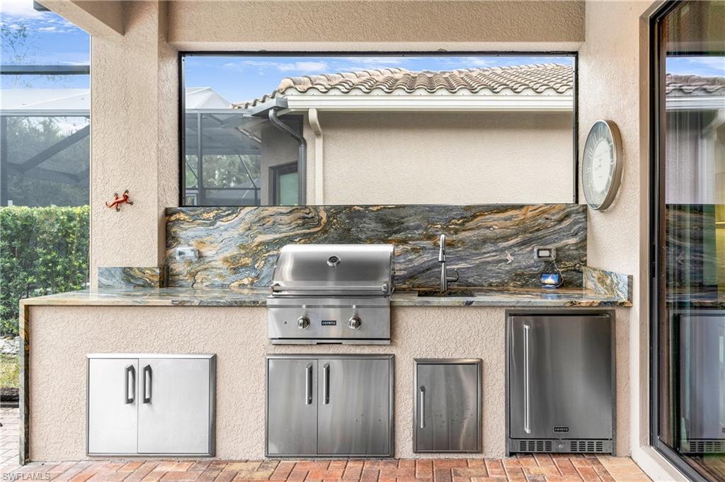 View of patio featuring exterior kitchen and a lanai