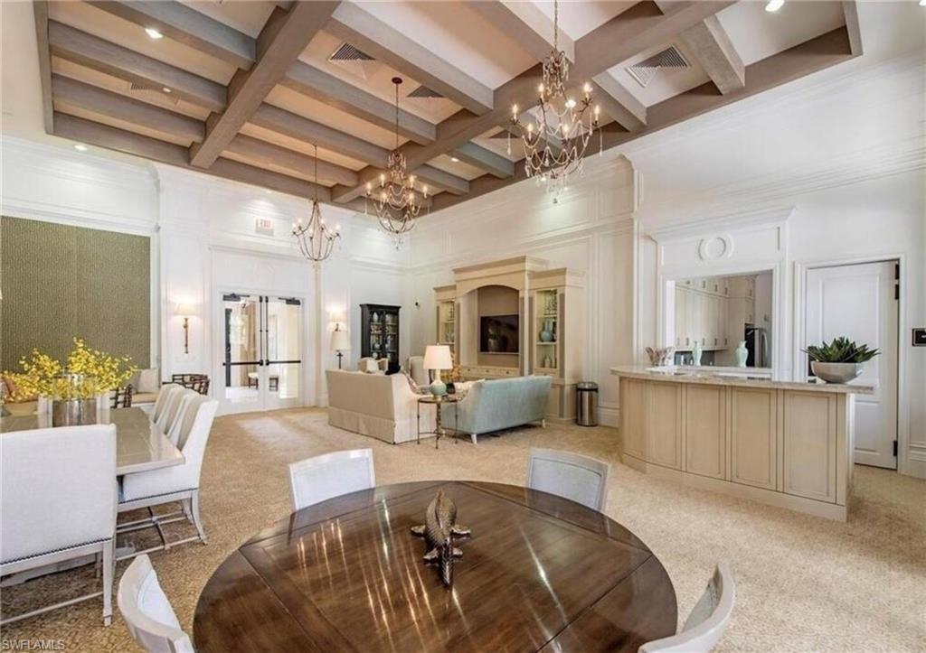 Dining space with french doors, coffered ceiling, beam ceiling, light colored carpet, and a towering ceiling