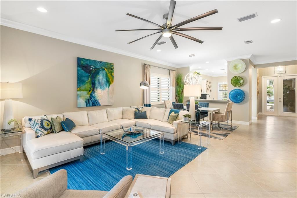 Living room featuring crown molding, ceiling fan, light tile patterned flooring, and recessed lighting