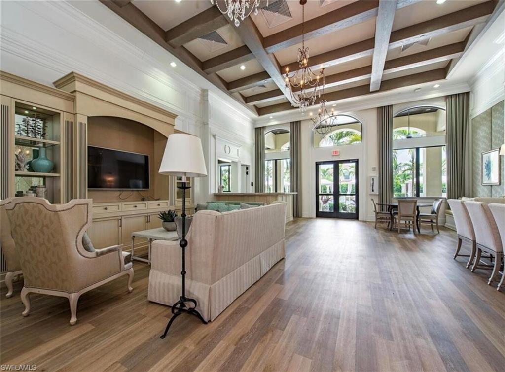 Living room featuring coffered ceiling, a high ceiling, wood finished floors, beamed ceiling, and french doors