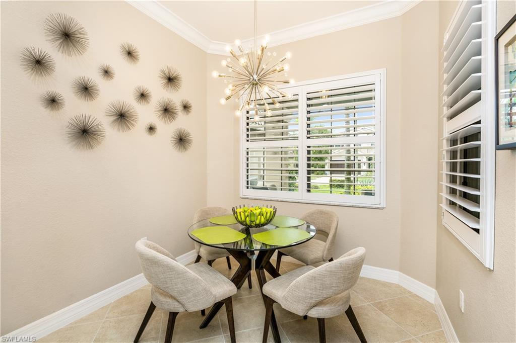 Dining space featuring crown molding, a chandelier, and light tile patterned flooring