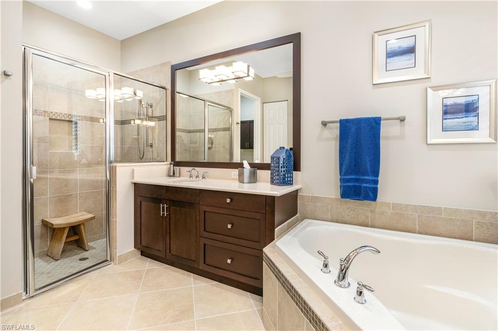 Bathroom featuring a garden tub, vanity, a shower stall, and light tile patterned floors