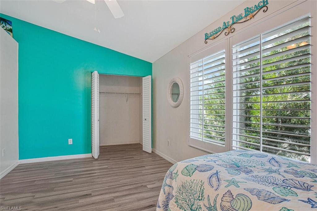 Bedroom featuring lofted ceiling, wood finished floors, a ceiling fan, and a closet