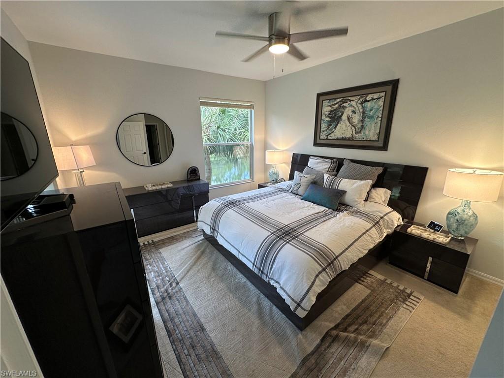 Carpeted bedroom with a ceiling fan