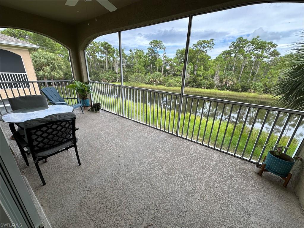 Sunroom / solarium with a water view and view of wooded area