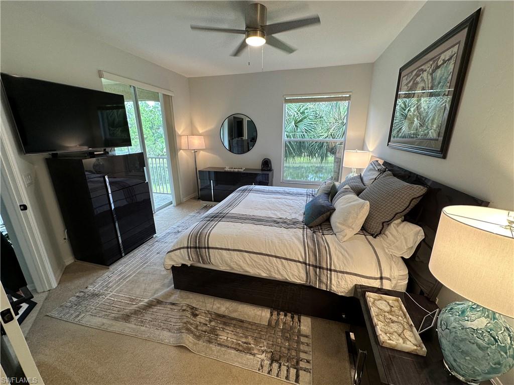 Bedroom featuring carpet flooring, access to exterior, ceiling fan, and multiple windows
