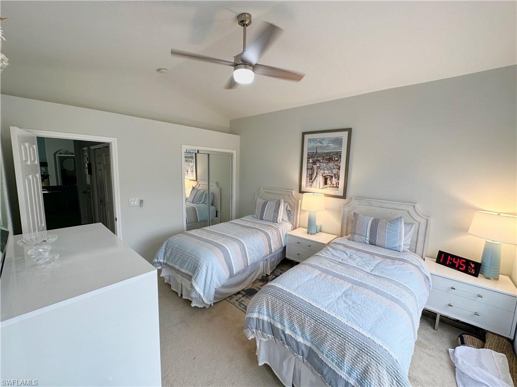 Carpeted bedroom with lofted ceiling, a closet, and ceiling fan