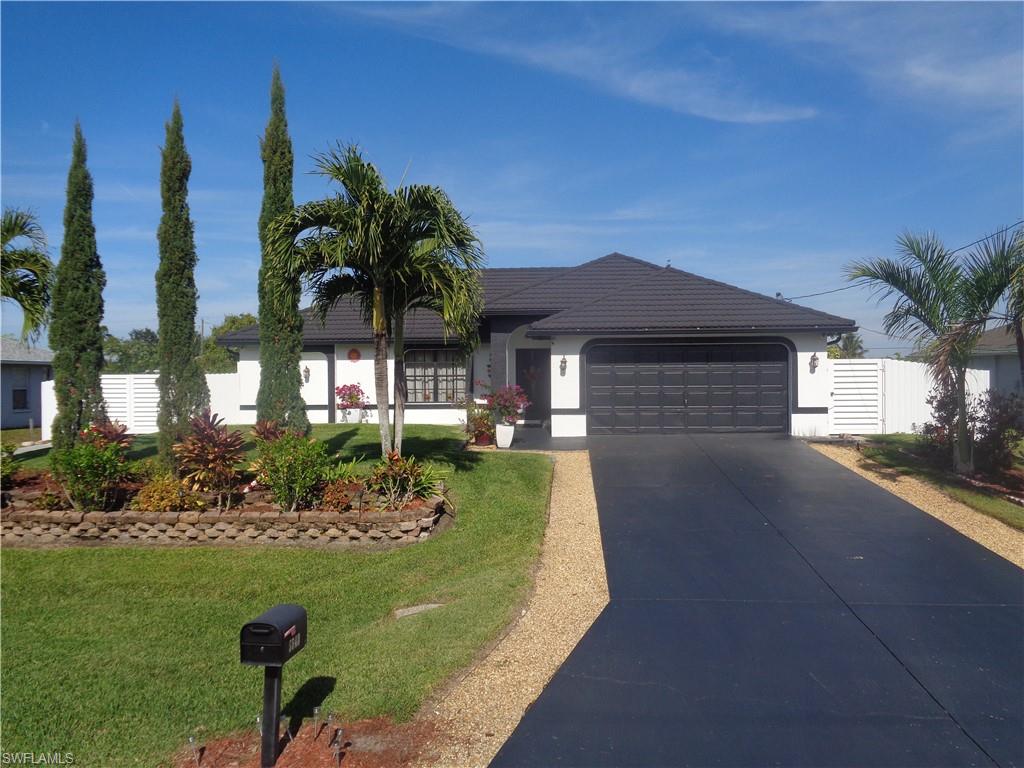 Front view of single story home featuring driveway, an attached garage, stucco siding, and metal roof