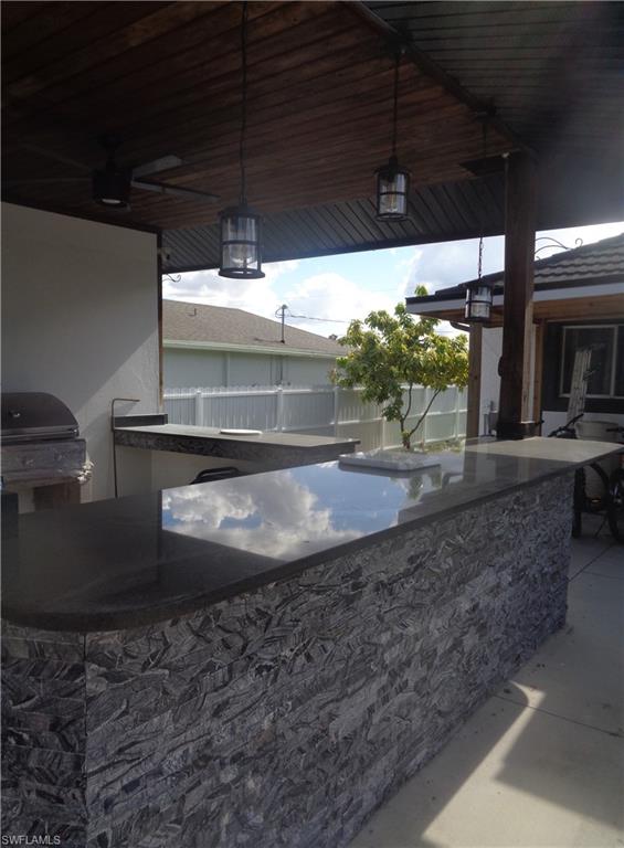 View of gazebo / terrace with area for grilling and a ceiling fan