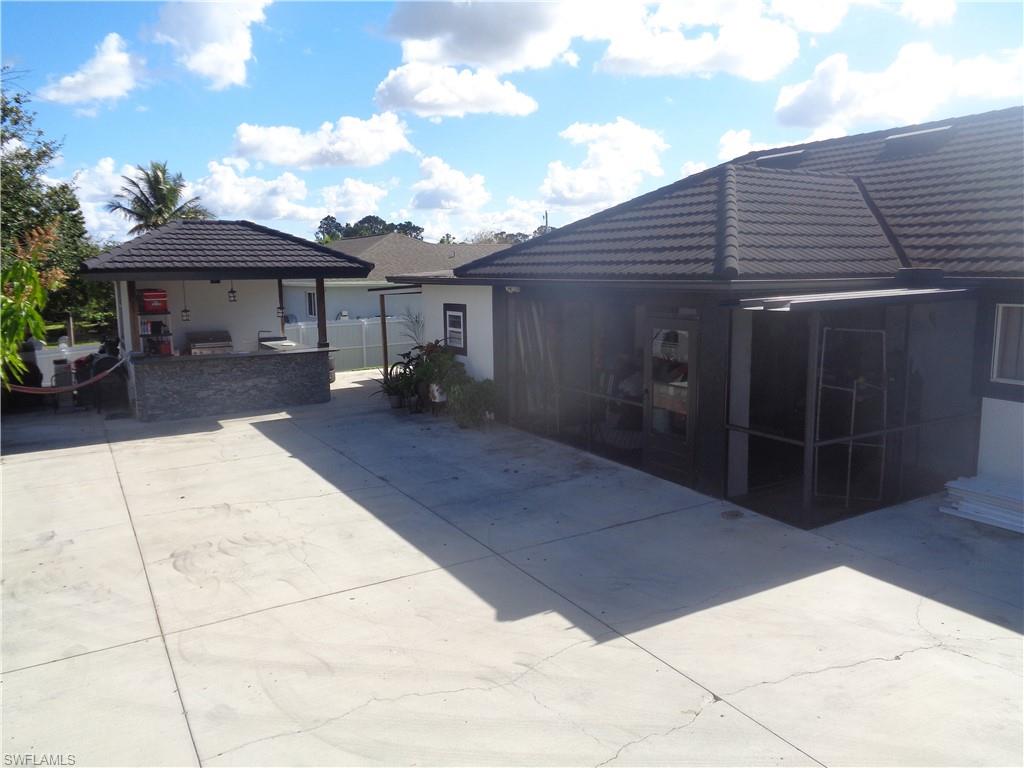 Rear view of house with metal roof, concrete patio, and a gazebo