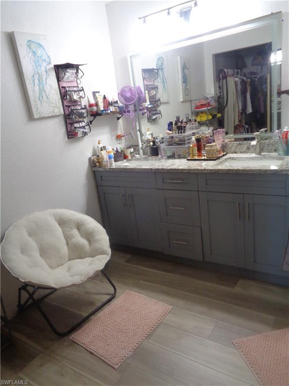 Master bedroom's bathroom featuring double vanity and light wood finished floors