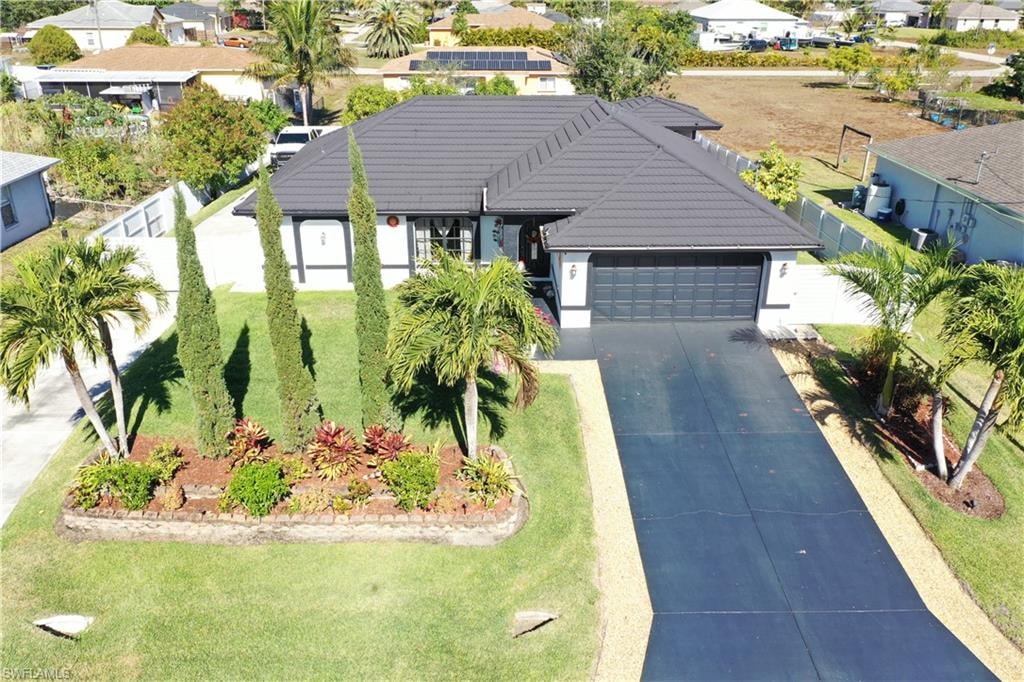 Single story home featuring a residential view, an attached garage, a tile roof, driveway, and stucco siding
