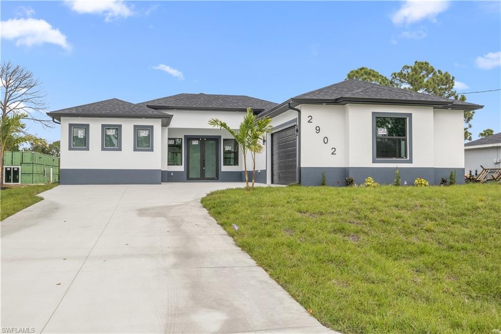 Prairie-style house featuring stucco siding, concrete driveway, a garage, and a shingled roof