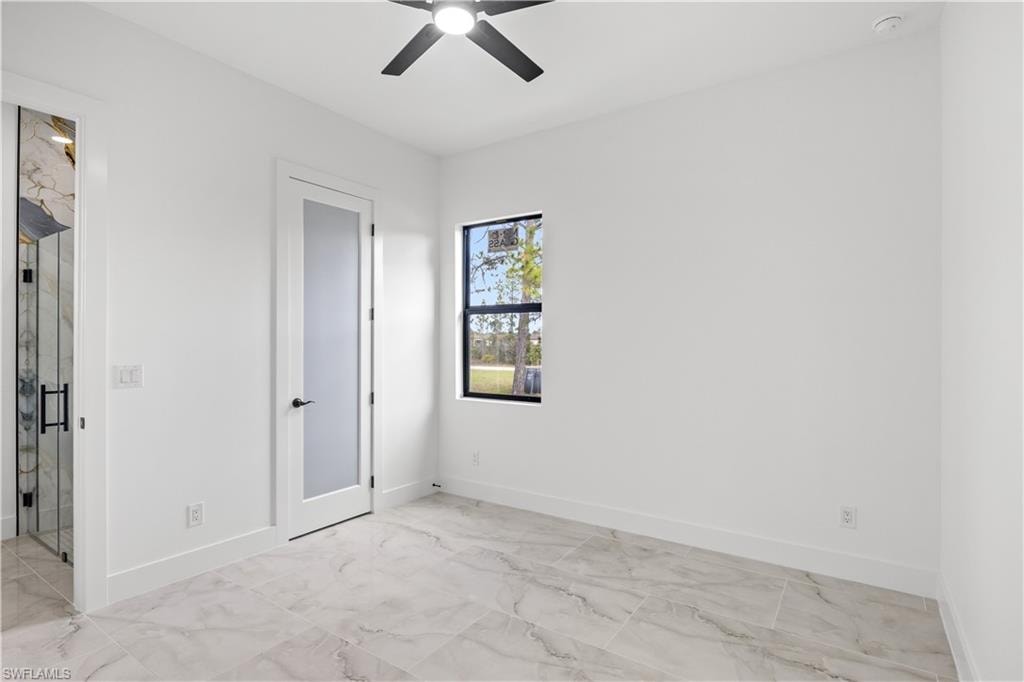 Unfurnished bedroom with a ceiling fan and light marble finish flooring