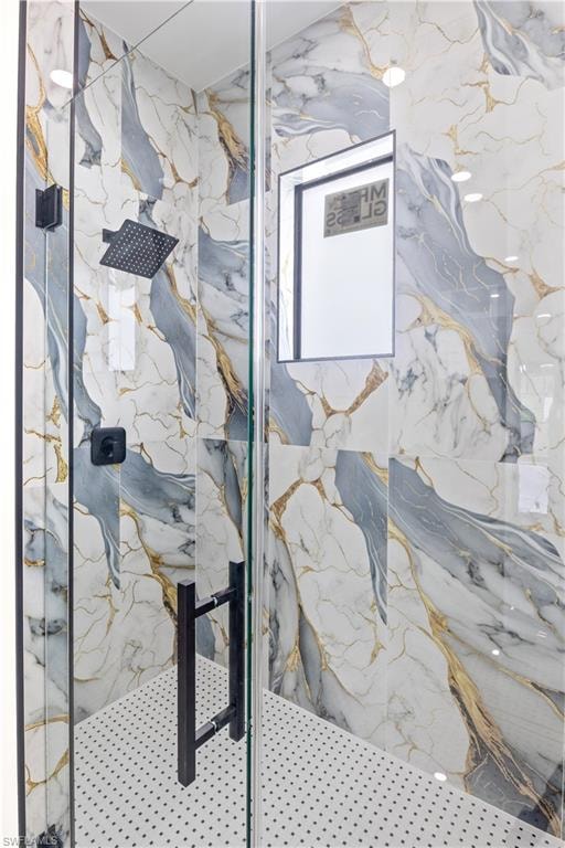 Full bath with a marble finish shower