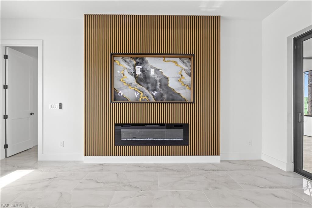 Detailed view of a glass covered fireplace and an accent wall